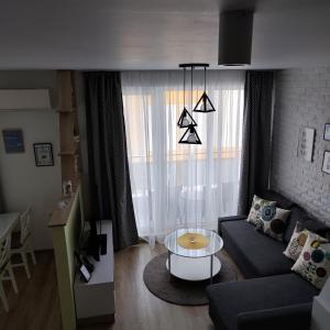 ein Wohnzimmer mit einem Sofa und einem Tisch in der Unterkunft AirLuxApartament in Burgas City