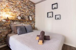 a bedroom with a bed with a brick wall at LE COSMO Du Grand Bassin Avec Terrasse in Castelnaudary