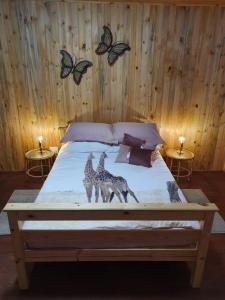 ein Schlafzimmer mit einem Bett mit zwei Giraffen drauf in der Unterkunft Hout Huisie in Marloth Park + 14 Fotos