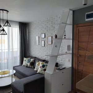 a living room with a couch and a stair case at AirLuxApartament in Burgas City