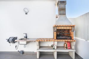 una griglia seduta su una panchina accanto a un tavolo di New Luxury Penthouse beachfront in the Algarve ad Armação de Pêra