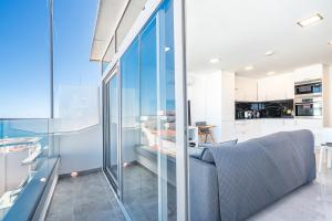 ein Wohnzimmer mit einem Sofa und einer Küche in der Unterkunft New Luxury Penthouse beachfront in the Algarve in Armação de Pêra