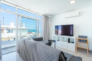 a bedroom with a bed and a large window at New Luxury Penthouse beachfront in the Algarve in Armação de Pêra