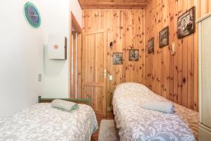 サン・ゼーノ・ディ・モンターニャにあるCasa Bella Vistaのベッド2台 木製の壁の部屋
