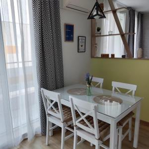 uma sala de jantar com uma mesa branca e cadeiras em AirLuxApartament em Burgas