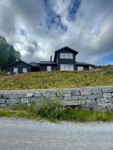 una casa en la cima de una colina con una pared de piedra en Modern cottage, en Sogndal