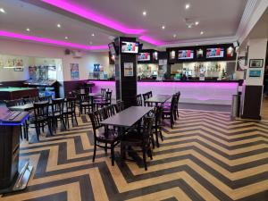 a restaurant with tables and chairs and a bar at Lucy's Lodge in Rhyl