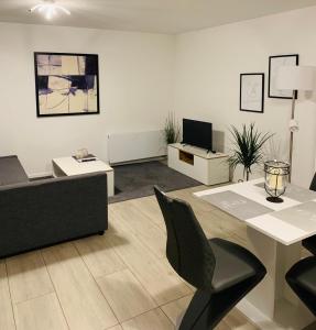 uma sala de estar com um sofá, uma mesa e cadeiras em Apartments WK em Colônia