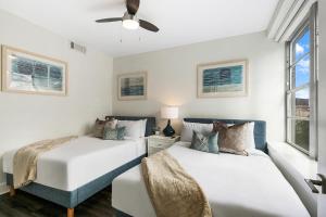 two beds in a room with two windows at Spacious Luxury 4BR Condo Moments from French Quarter in New Orleans
