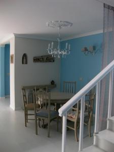 uma sala de jantar com uma mesa e cadeiras e um lustre em Villa Spozendus em Esposende
