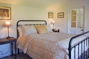 um quarto com uma cama e 2 candeeiros nas mesas em The Red Shed Entire home for 2 Private garden and parking 2 miles from Bury St Edmunds em Whepstead