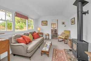 uma sala de estar com um sofá e um fogão em The Red Shed Entire home for 2 Private garden and parking 2 miles from Bury St Edmunds em Whepstead