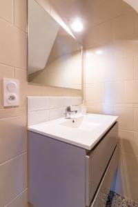 bagno bianco con lavandino e specchio di AU PIED Du Grand Bassin a Castelnaudary