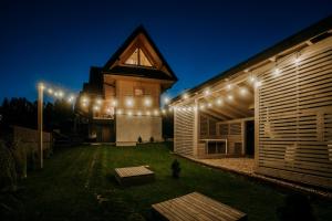 a house with a lit up yard at night at Mleko domki in Białka Tatrzanska