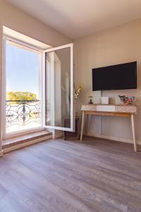 un soggiorno con una grande finestra e una TV a schermo piatto di AU PIED Du Grand Bassin a Castelnaudary