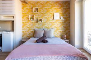 1 dormitorio con 1 cama grande y pared amarilla en AU PIED Du Grand Bassin, en Castelnaudary