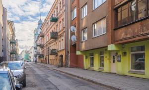 una calle de la ciudad con edificios y coches aparcados en la calle en Station Self Check-in Apartments - Lollo Luxury en Vilna