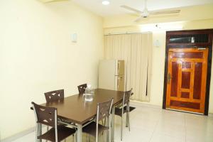uma sala de jantar com uma mesa e cadeiras e um frigorífico em SATK INN Jaffna, Kokkuvil 