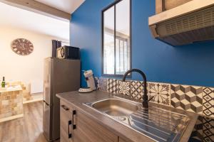 uma cozinha com um lavatório e um frigorífico em LE COSMO Du Grand Bassin Avec Terrasse em Castelnaudary