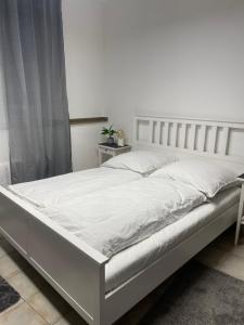 a bed with white sheets and pillows in a bedroom at SleepWell1 in Cologne