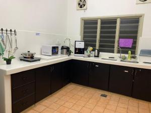 a kitchen with a sink and a counter with a microwave at SSR 41 SEREMBAN TOWN 4R3B homestay in Seremban