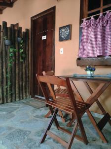 a wooden chair sitting in front of a table at TEMPLÁRIOS ECOVILLA Pousada in Pirenópolis