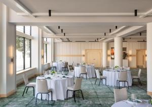 - une salle de banquet avec des tables et des chaises blanches dans l'établissement Hotel Verdant, à Racine