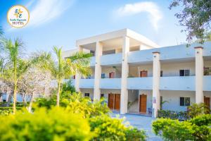 a white building with palm trees in front of it at Hotel Santa Engracia in Ciudad Valles