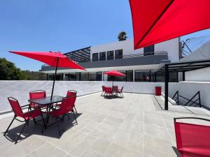 a patio with red chairs and tables and umbrellas at Suite a 15 minutos de Polanco y Santa Fe in Mexico City