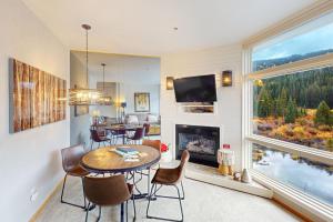 a living room with a table and chairs and a fireplace at River Bank Lodge 2924 in Keystone