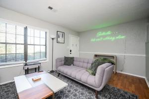 a living room with a purple couch and a table at Vibrant Family Retreat~Sleeps 8~2 Kings~ Game Room in Snellville