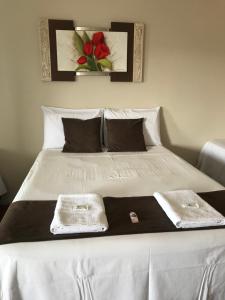 a large white bed with two towels on it at Pousada Sabia Capitolio in Capitólio