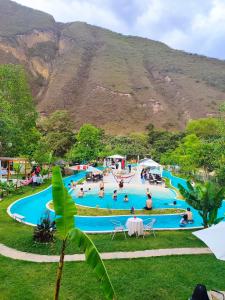 a group of people in a swimming pool with a mountain in the background at Zoila's Suite Escape in Nuevo Tingo