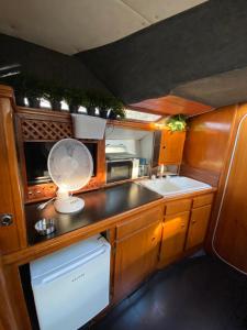 a kitchen with a fan and a sink and a microwave at Experiencia en el mar Gijon M in Gijón