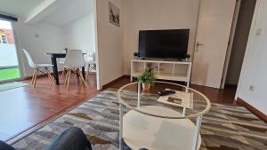a living room with a table and a tv at Ático Magdalena - WIFI in Ferrol