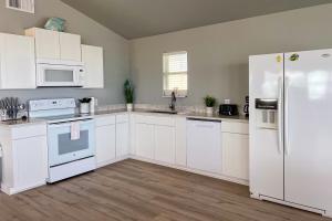 a kitchen with white appliances and white cabinets at Bayalicious in Rockport