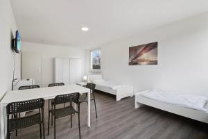 a white room with a bed and a table and chairs at Wohnung mit Balkon in Wuppertal in Wuppertal