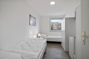 a white bedroom with a bed and a window at Wohnung mit Balkon in Wuppertal in Wuppertal