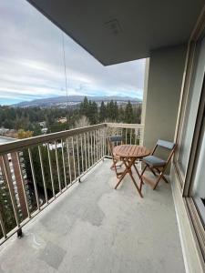 balcón con mesa y sillas en Urban Retreat with Pool, Sauna, and 18th-Floor Oceanfront Views en North Vancouver