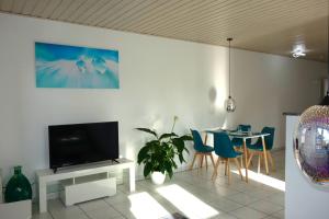 uma sala de estar com uma televisão e uma mesa com cadeiras em HAPPY HOMES - Up to 5 - Küche - W-LAN - Netflix - Honig - Balkon em Nidda