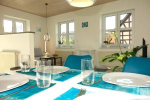 a dining room table with plates and glasses on it at HAPPY HOMES - Up to 5 - Küche - W-LAN - Netflix - Honig - Balkon in Nidda