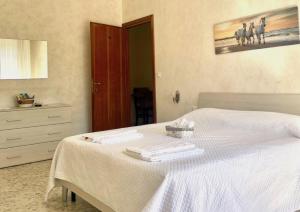 a bedroom with a white bed with towels on it at Le Ville Suites, Tivoli City Center! in Tivoli
