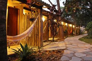 a fence with a hammock in front of a house at TEMPLÁRIOS ECOVILLA Pousada in Pirenópolis