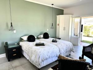 Un dormitorio con una cama con dos objetos negros encima. en Sea-esta, en Plettenberg Bay 27 fotos más