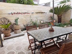 patio ze stołem, krzesłami i roślinami w obiekcie Domus Antiqua - Enjoy House! w mieście Lizzanello