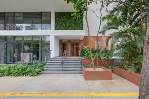 um edifício com escadas e palmeiras em frente em Roomo Brooklin Morumbi Ejoy Residencial em São Paulo