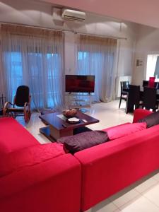 ein Wohnzimmer mit einem roten Sofa und einem Tisch in der Unterkunft ΜΕΖΟΝΈΤΑ in Síndos