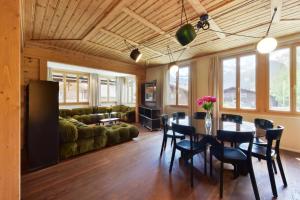 ein Wohnzimmer mit einem Tisch, Stühlen und einem Sofa in der Unterkunft Ferienlenk Mountain Village in Lenk im Simmental