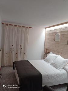 1 dormitorio con 1 cama grande con sábanas y almohadas blancas en Casa Rural Felip en Espot