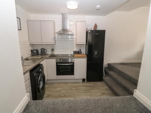 a kitchen with a black refrigerator and a dishwasher at 1 Dulas Apartments in Abergele